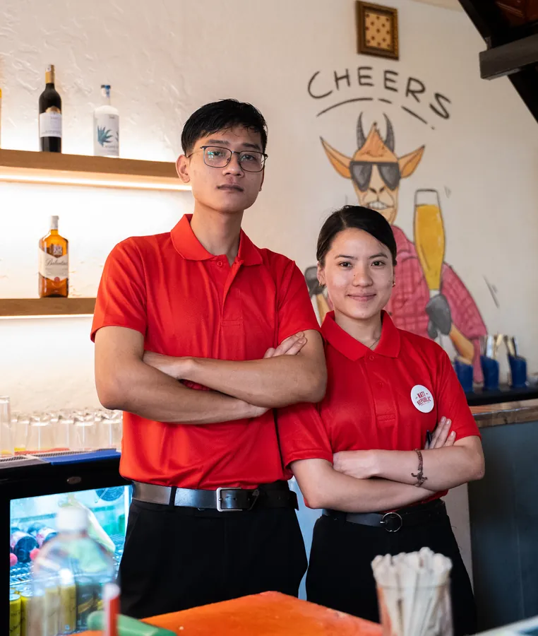 Two of the team in red Nati Republic shirts at the counter.