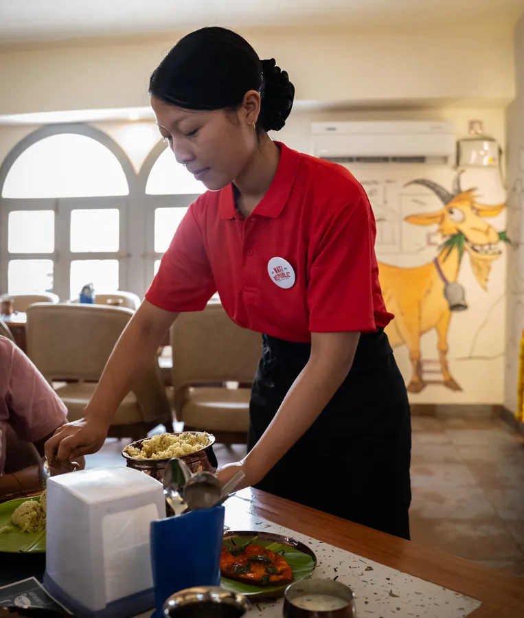 A server serving at a table.