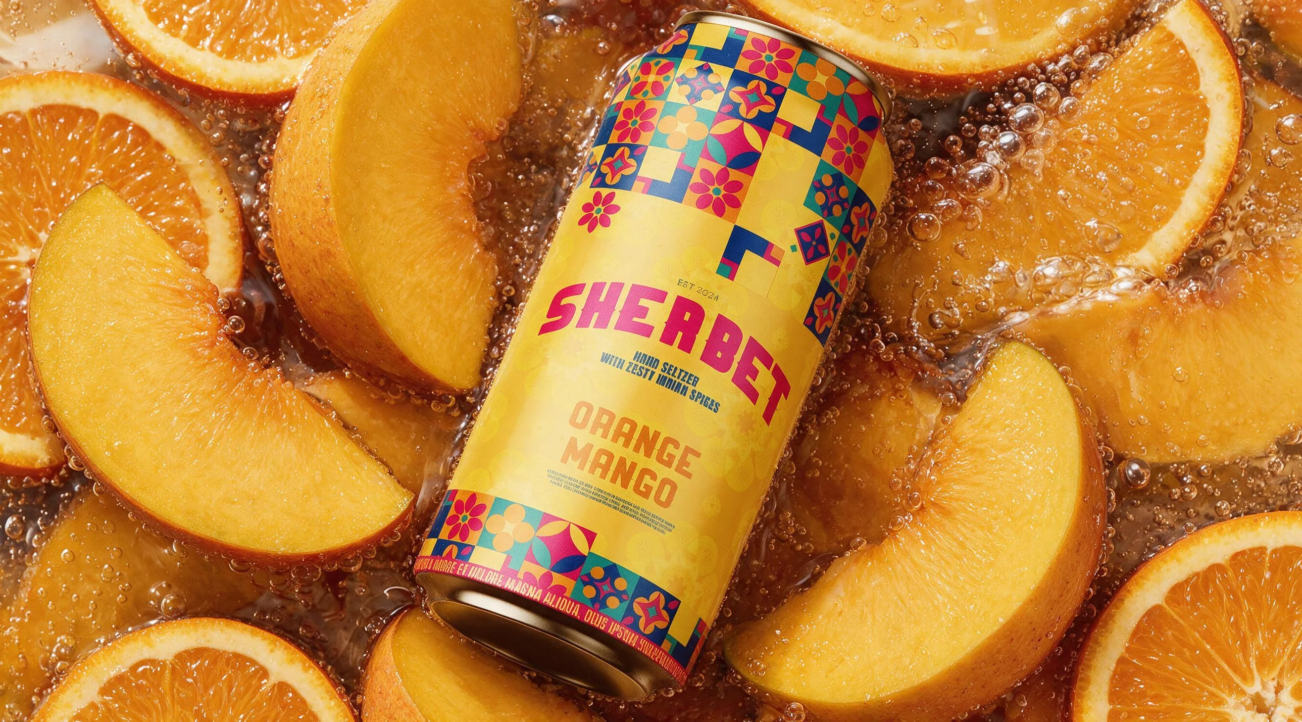 A Sherbet Orange Mango can lying in a pile of cut oranges and peaches.