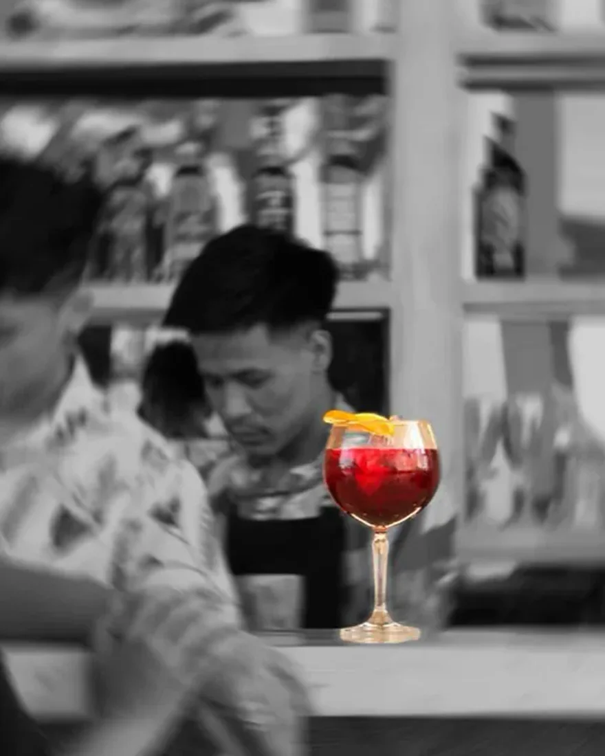 A cocktail glass holding the only colour in a black-and-white bar